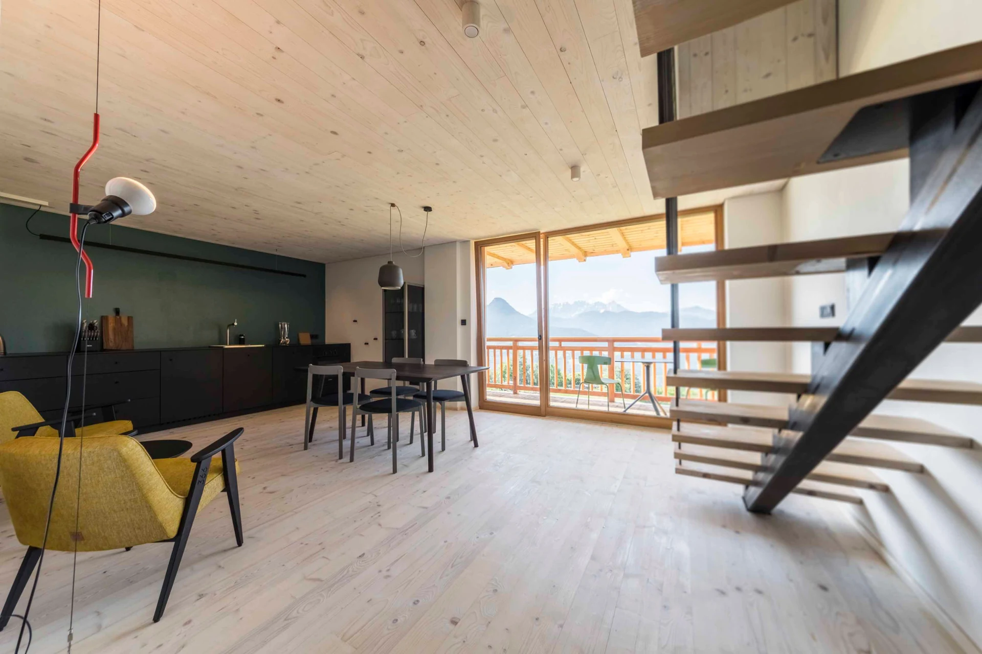 Wohnküche mit Holztreppe und weitem Ausblick