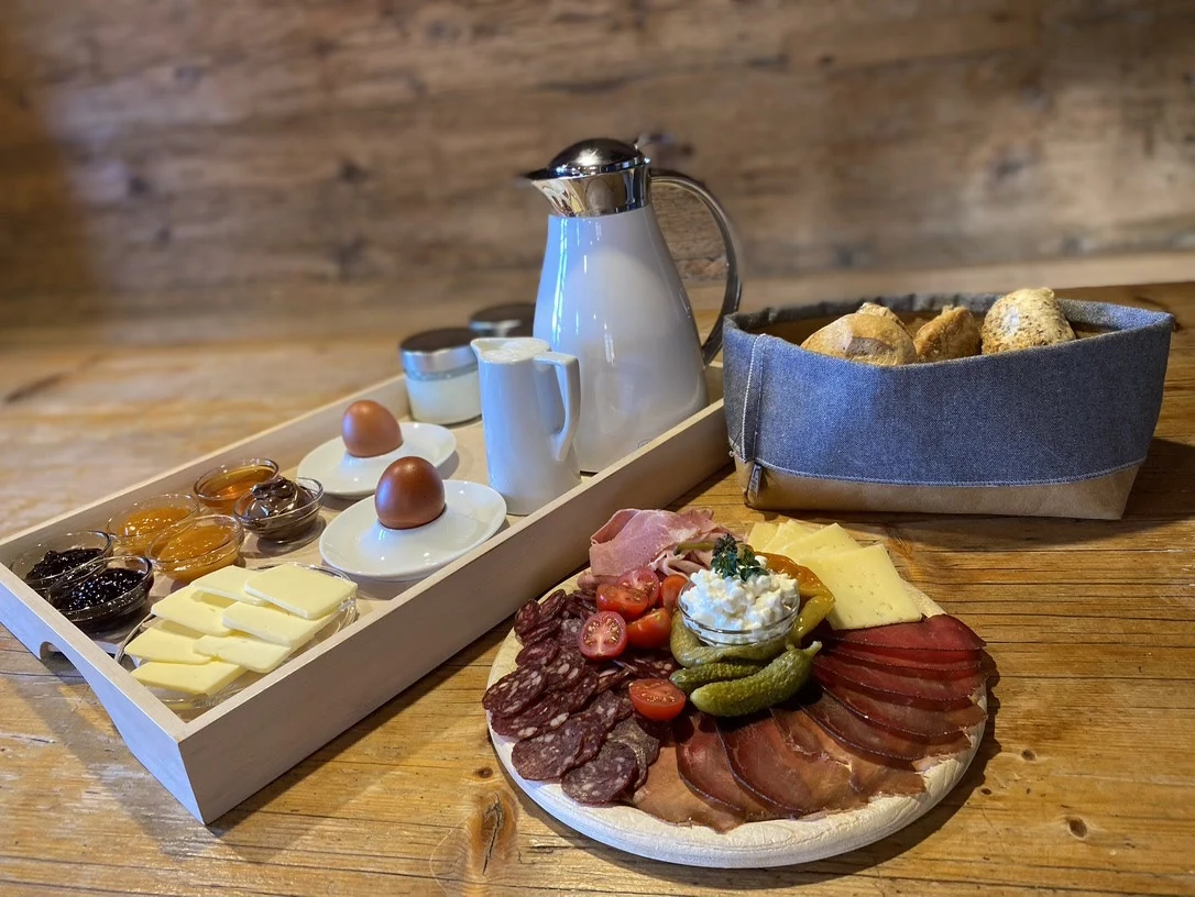 Frühstück mit Brot, hofeigenen Produkten und Getränken